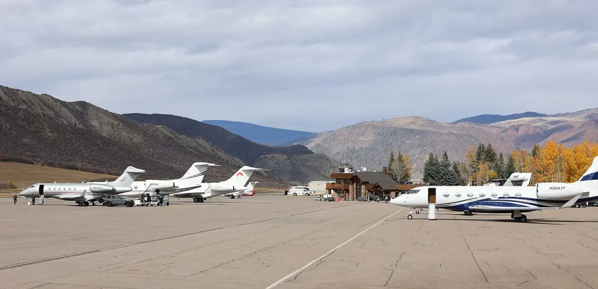 Aircraft on the apron at Aspen–Pitkin County Airport with mountains behind