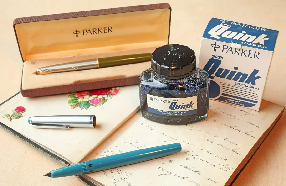 Parker fountain pens with a bottle of Quink ink